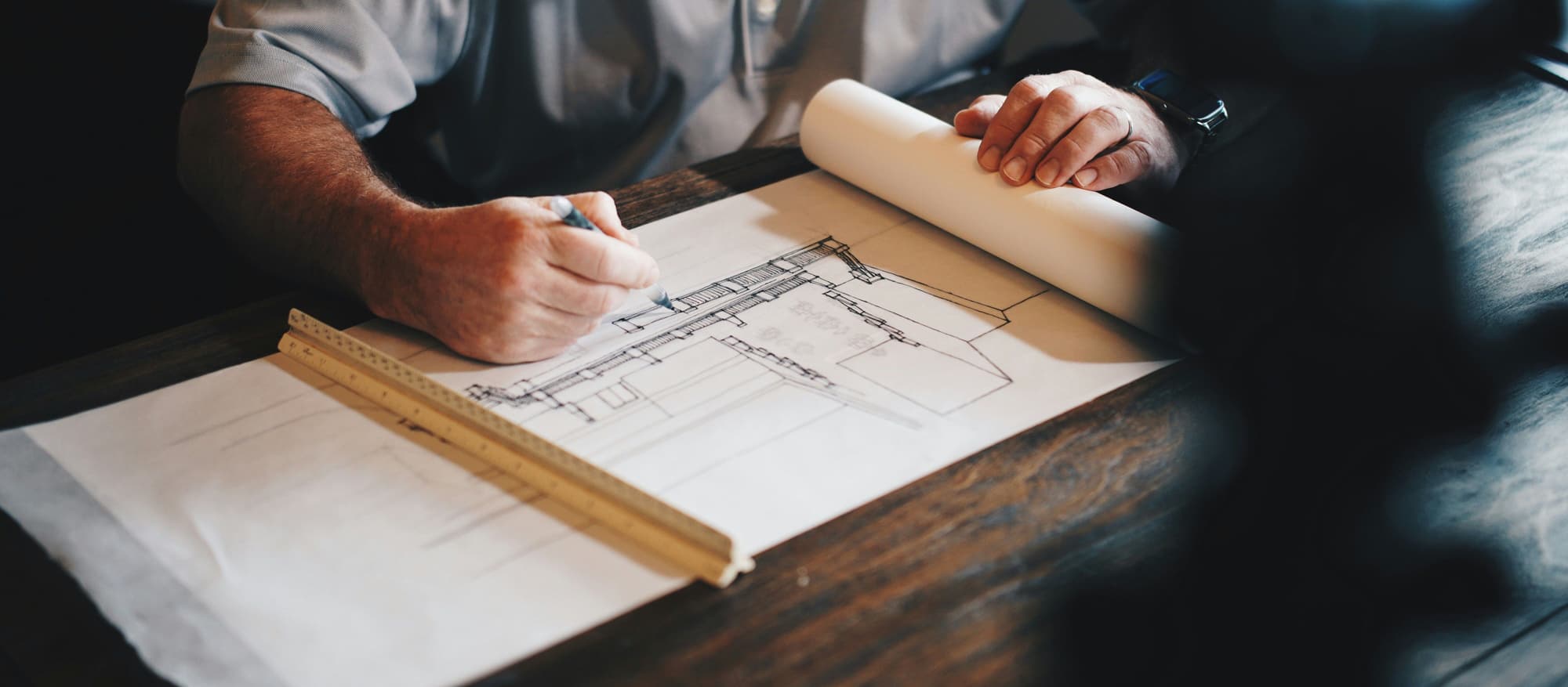 A person reviewing and annotating architectural drawings