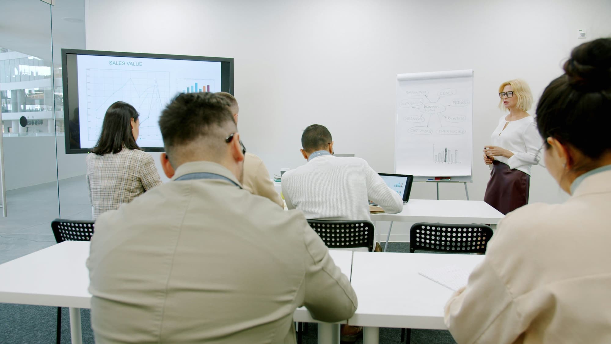 A presenter leading a training session in a modern conference room